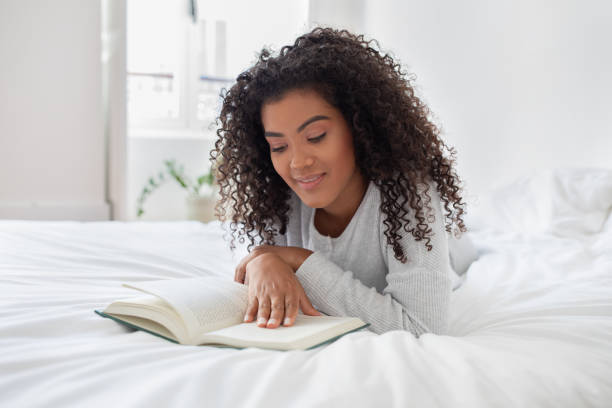 istock Woman Laying on Bed Reading a Book 2158385977