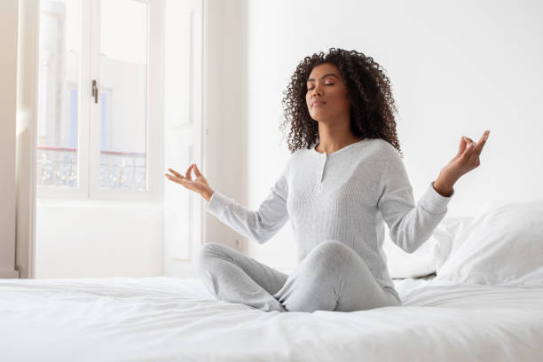 istock Young Woman Practicing Morning Meditation on Her Bed 2158385979