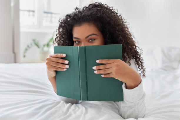 Young Woman Engrossed in Reading a Green Book