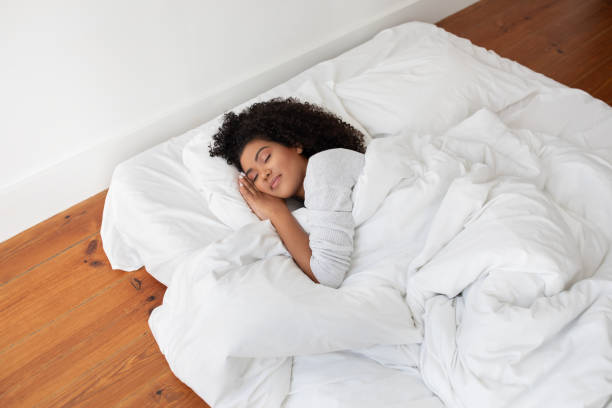 istock Woman Laying in Bed With White Comforter 2158386008