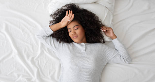 istock Woman Laying in Bed With Hands on Head 2158386012