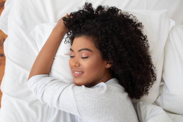 istock Woman Laying in Bed With Closed Eyes, Head on Pillow 2158386023
