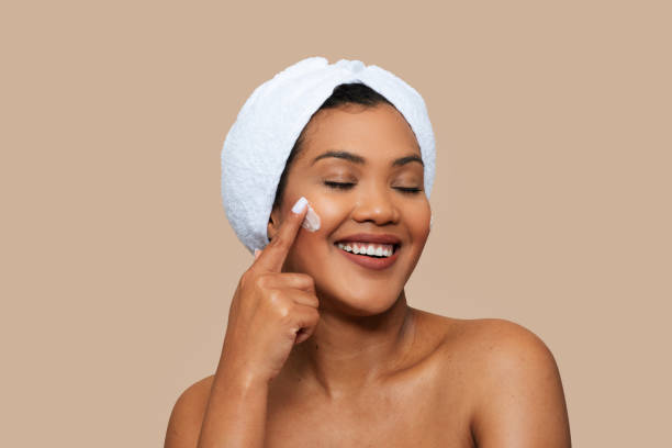istock Woman Applying Face Cream With Towel on Head 2158386114