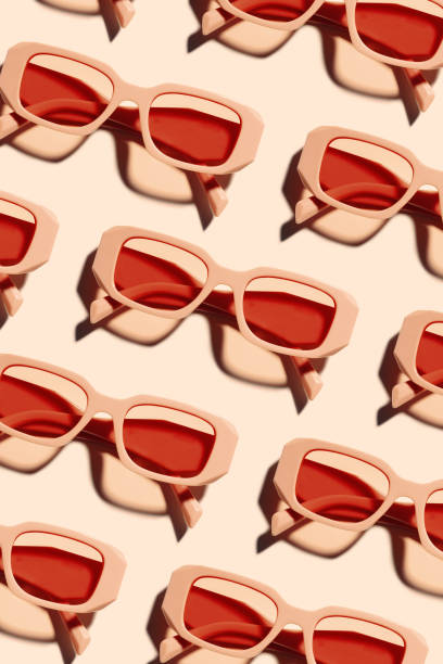 istock Minimal pattern of Stylish sunglasses with pink Frame on peach beige color background, sunlight shadow, summer fashion plastic-framed glasses. Aesthetic top view eyewear, geometric patterns 2158386325