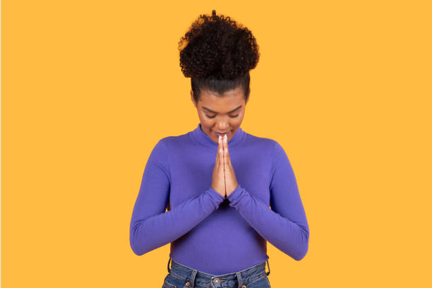 istock Woman Standing With Folded Hands on Yellow 2158386375