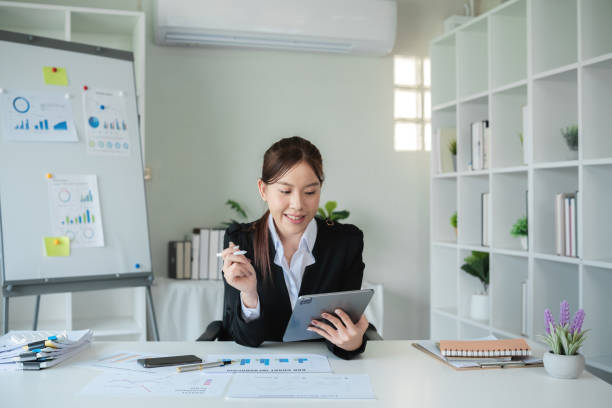 istock Professional Female Accountant Working in Modern Office Analyzing Financial Data on Tablet 2158392289
