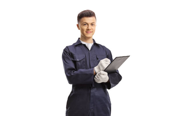 istock Young mechanic worker in a uniform writing on a clipboard 2158392609