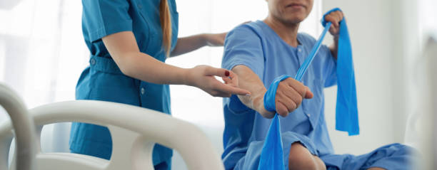 istock Elderly Patient Receiving Physical Therapy from Young Female Therapist Using Resistance Bands in Modern Clinic 2158393006