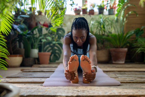 istock Athletic african american woman do flexibility exercise warm up muscles legs stretching back at home 2158396306