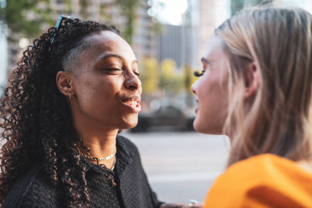 istock LGBTQ couple talking and smiling in an urban setting during sunset. The image captures a candid moment of joy, love, and connection in the hustle and bustle of city life. 2158396903