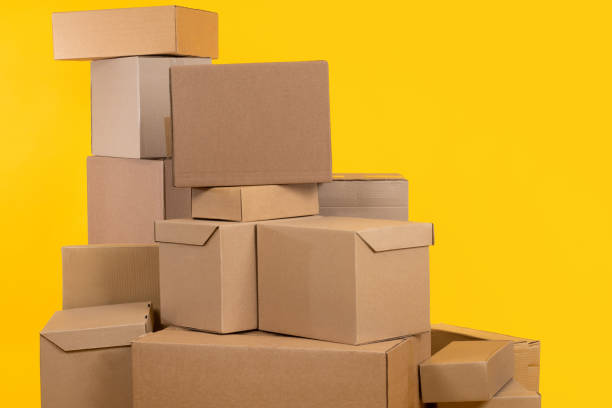 istock Boxes of various sizes. Several boxes are in pile. Cardboard boxes on yellow background. Concept of parcels ready to be sent. Metaphor cardboard with goods from online store. Courier shipments 2158396993