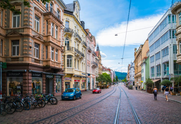 Freiburg im Breisgau, Germany, July 23, 2023, Old town historical buildings with colorful facades, shops, restaurants and appartments in side, alongside rails of tramway