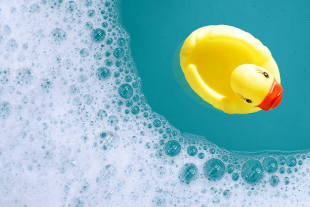 istock Yellow rubber duck in water with soap foam 2158397299