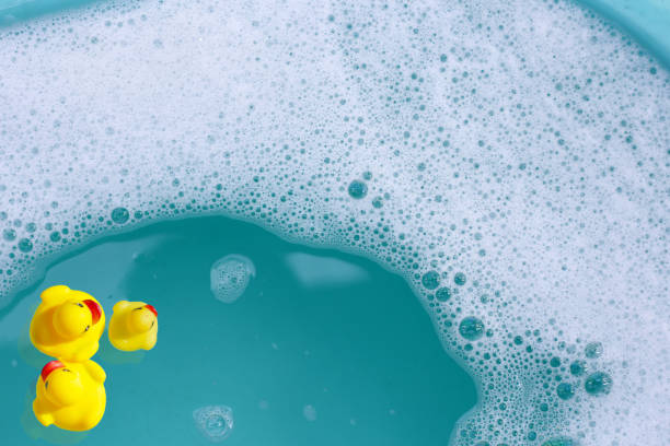 istock Yellow rubber ducks in water with soap foam 2158397303