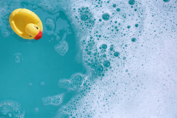 istock Yellow rubber duck in water with soap foam 2158397362