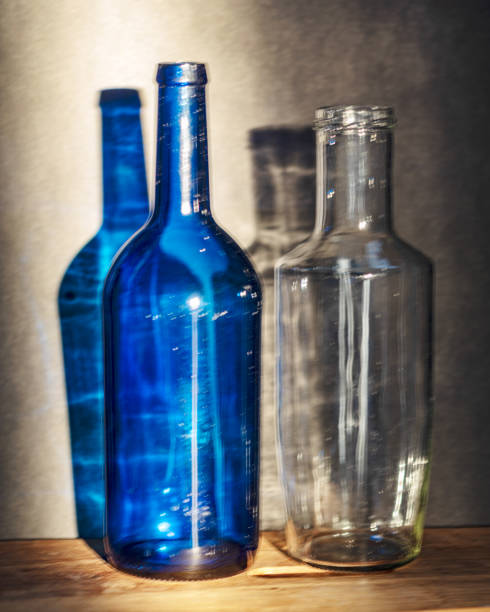 istock Still life with blue glass bottles, quiet shadows in the background, soft evening light 2158398557