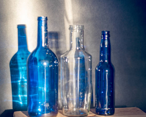 istock Still life with blue glass bottles, quiet shadows in the background, soft evening light 2158398655