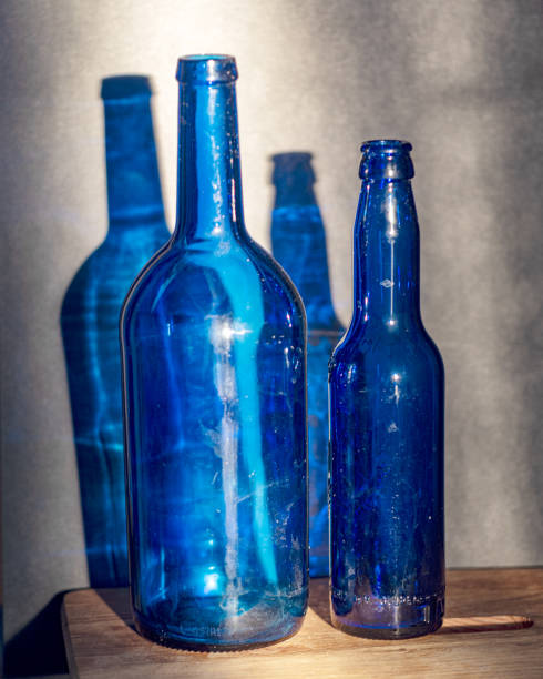 istock Still life with blue glass bottles, quiet shadows in the background, soft evening light 2158398684