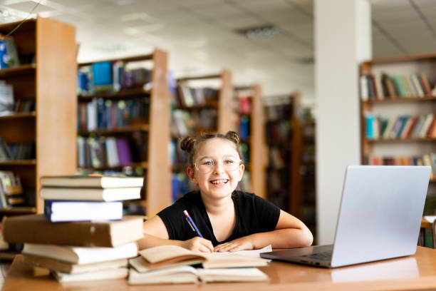 istock schoolgirl spends time in the library 2158400594