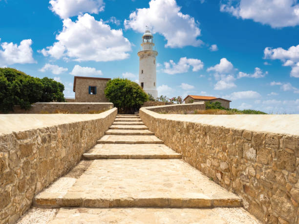 istock Cyprus sights. Pathos architecture. White lighthouse on background of sky. Lighthouse on Mediterranean sea. Cyprus vacation. Pathos on summer day. Lighthouse near stone steps. Tours in Cyprus 2158401408