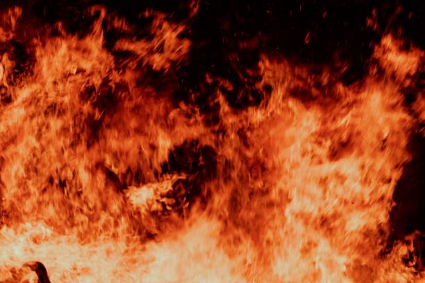 A close-up view of a large fire with intense flames against a dark background