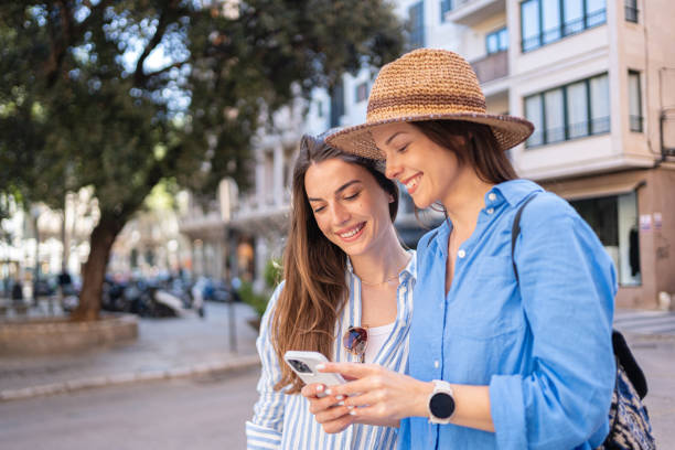istock Two young women using a phone while exploring the city landmarks of Palma de Mallorca 2158404078