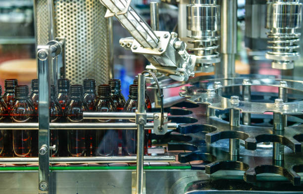 istock Glass bottles in a conveyor belt on a high quality automatic vertical filling machine. 2158404958