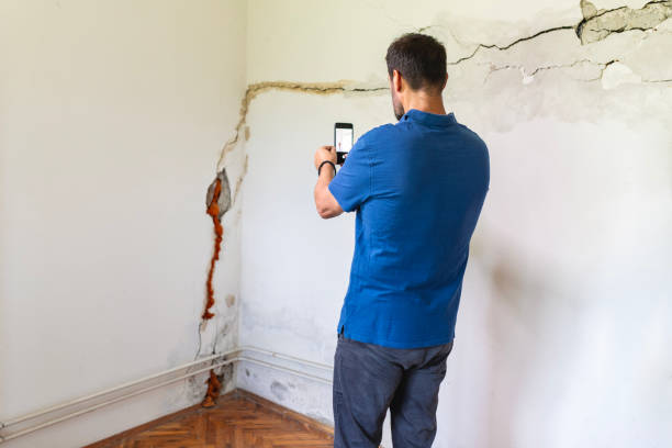Mature man looking at a  damaged wall