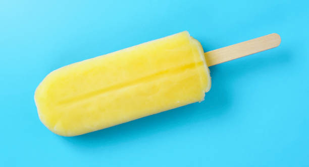 istock Close up of a yellow popsicle on the light blue background. 2158411050