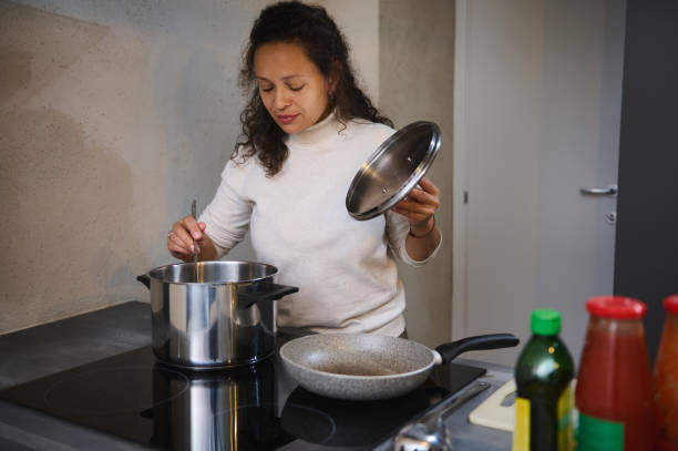 istock Woman cooking in modern kitchen, stirring ingredients in pot 2158411207
