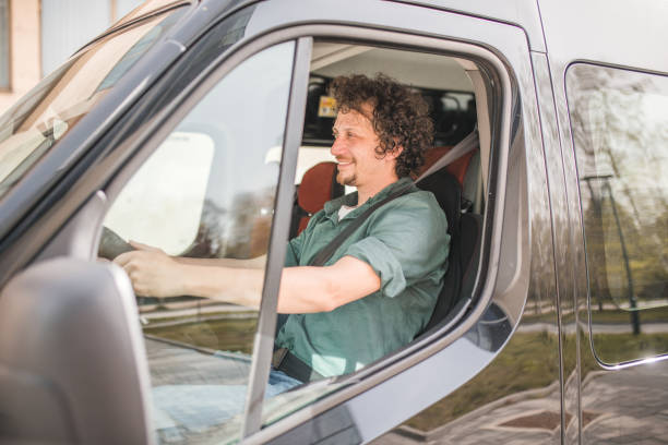 istock A cheerful bus driver drives the minibus with caution 2158412245