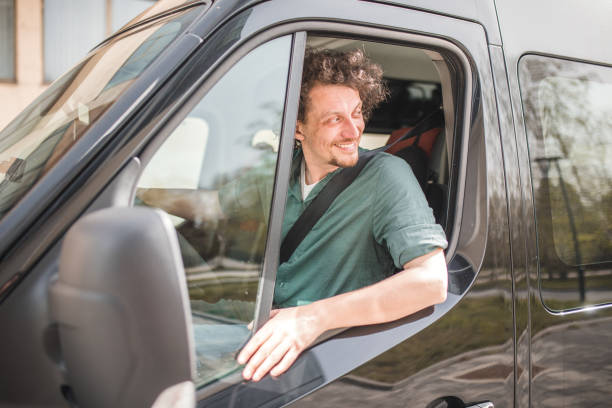 istock A smiling bus driver drives the minibus with caution 2158412488