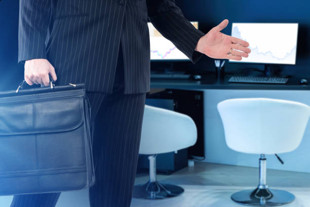 businessman holds out his hand. Briefcase is in hands of terder. Investor pulls out his hand for handshake. Man with business briefcase. Trader's workplace is behind him. Business agreements concept el hombre de negocios extiende su mano. el maletín está en manos de terder. el inversor saca la mano para darle un apretón de manos. hombre con maletín de negocios. el lugar de trabajo del comerciante ha quedado atrás. concepto de acuerdos comerciales