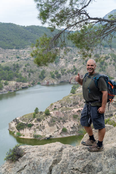 istock A strong man hiker poses smiling on a rock outdoors 2158415452