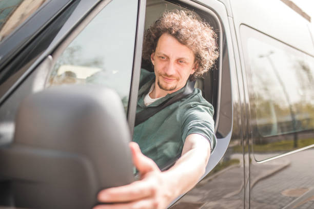 istock The minibus driver drives the minibus and adjusts the rearview mirror 2158416246