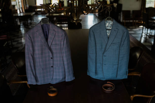 Two fashionable suit jackets displayed on the table in a wedding venue, waiting for the groom's to prepare for their marriage ceremony.