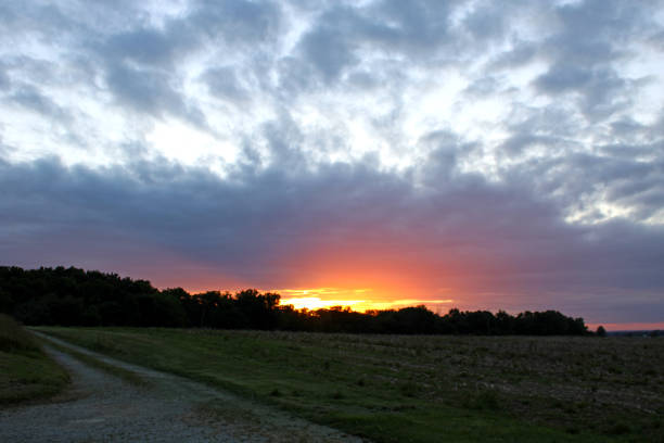 Sunset on the farm in Ohio USA - bright orange looks like fire blazing above the treeline