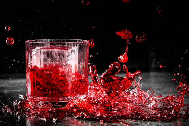 istock Dynamic red liquid splashing in a glass against a dark background 2158423284