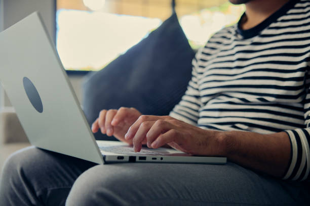 istock Man comfortably using a laptop on a couch for leisure 2158424556