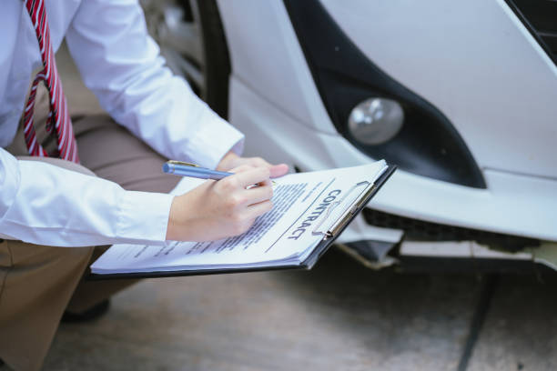 istock Insurance concept, insurance agent checking broken car and submit a claim form after an accident traffic accident 2158426064