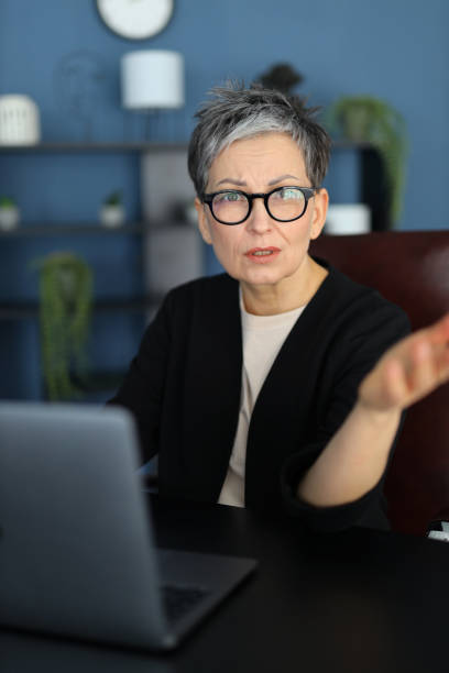 istock Senior businesswoman gesturing while working on her laptop, showcasing technology and professionalism in the office. 2158428030