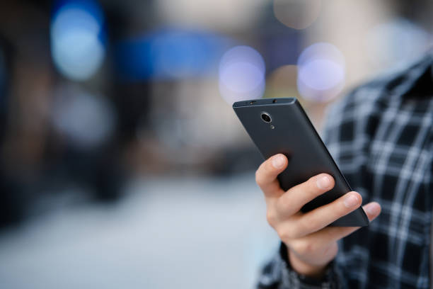 istock Young man using smartphone in city street 2158428046