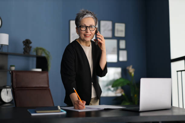 istock Professional woman talking on a smartphone, highlighting modern communication and efficiency in a business setting. 2158428465