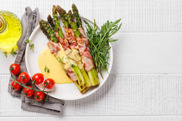 istock Grilled asparagus with bacon and egg sauce on a plate 2158428584