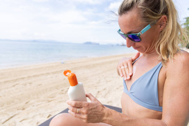 istock Woman Applying Sunscreen on Beach 2158429174