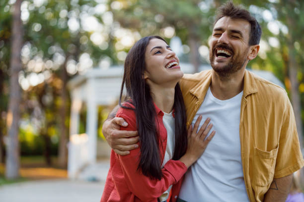 istock Happy couple laughing together in park setting. 2158431405