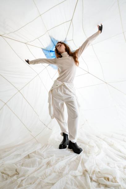 istock Young Woman Posing in a White Room With a Net Ceiling 2158432716