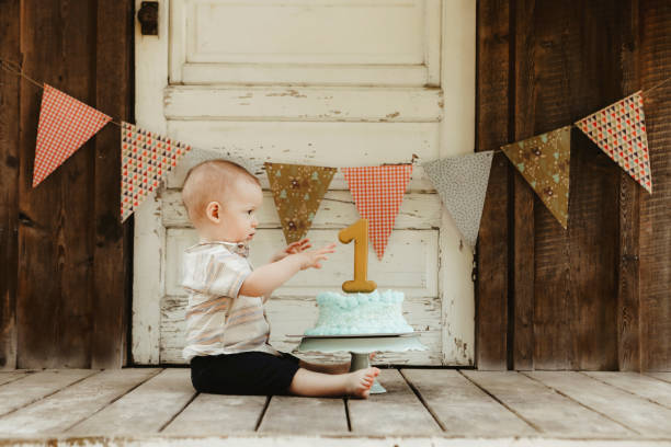 istock One Year Old Baby Boy With His Birthday Cake 2158434309