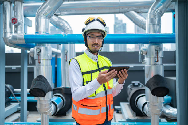 istock Engineer under checking the industry chilled water fan coil unit air conditioner is water cooling tower air chiller HVAC system of large industrial building to control air system 2158436526