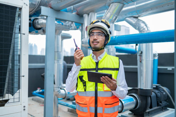 istock Engineer under checking the industry chilled water fan coil unit air conditioner is water cooling tower air chiller HVAC system of large industrial building to control air system 2158436636